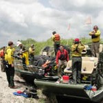 A group of U.S. Fish and Wildlife Service firefighters and the production crew of a Discovery Channel show preparing to ride two airboats.