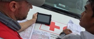 Two men looking at maps and a mobile device.