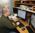 Administrative worker at his desk looking at monitor.
