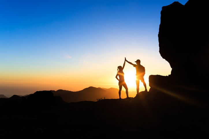 Couple high-fiving at sunset.