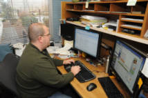 Administrative worker at his desk looking at monitor.