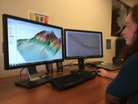 Someone viewing data imagery on two desktop monitors.