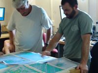 Two men standing at a table looking at a map.